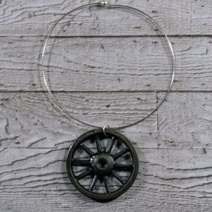 statement black necklace - vintage wheel neck cuff on grey concrete background