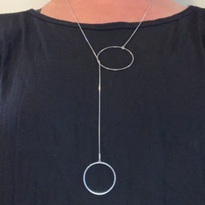 H5O steel circles lariat being worn on black top