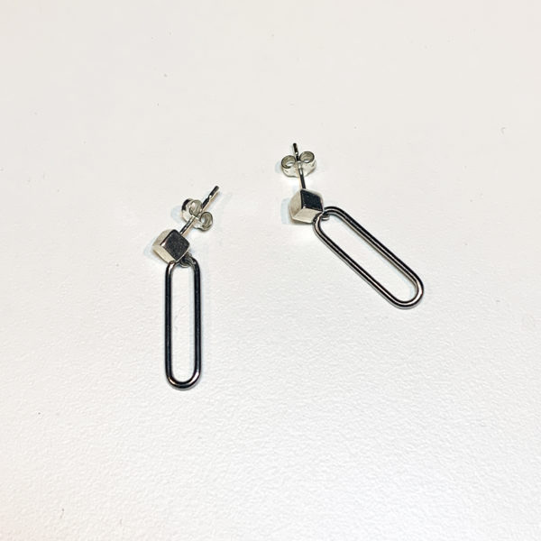 steel paperclip earrings with silver cube stud on white background