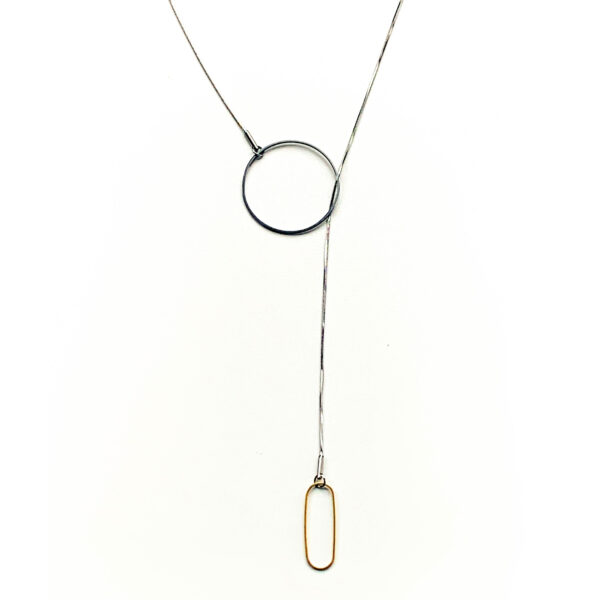 A stainless steel lariat necklace featuring a brass lozenge shape at the end. It is shown on a white background and designed and made by Factory Floor Jewels in Liverpool